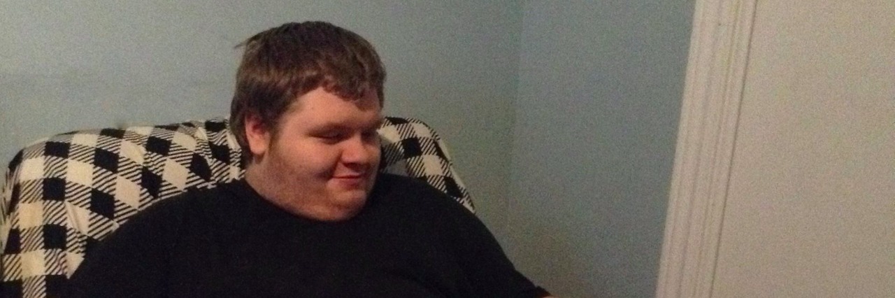 Having an Adult Son With Autism in Ontario young man sitting in chair with two cats