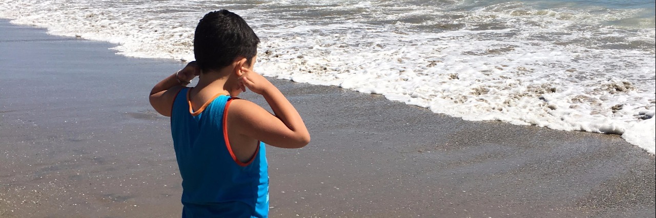 Mom Writes Letter to Nervous Parent of Child on the Autism Spectrum little boy with autism covering his ears at the beach