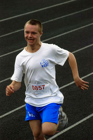 a boy with down syndrome running in a track meet
