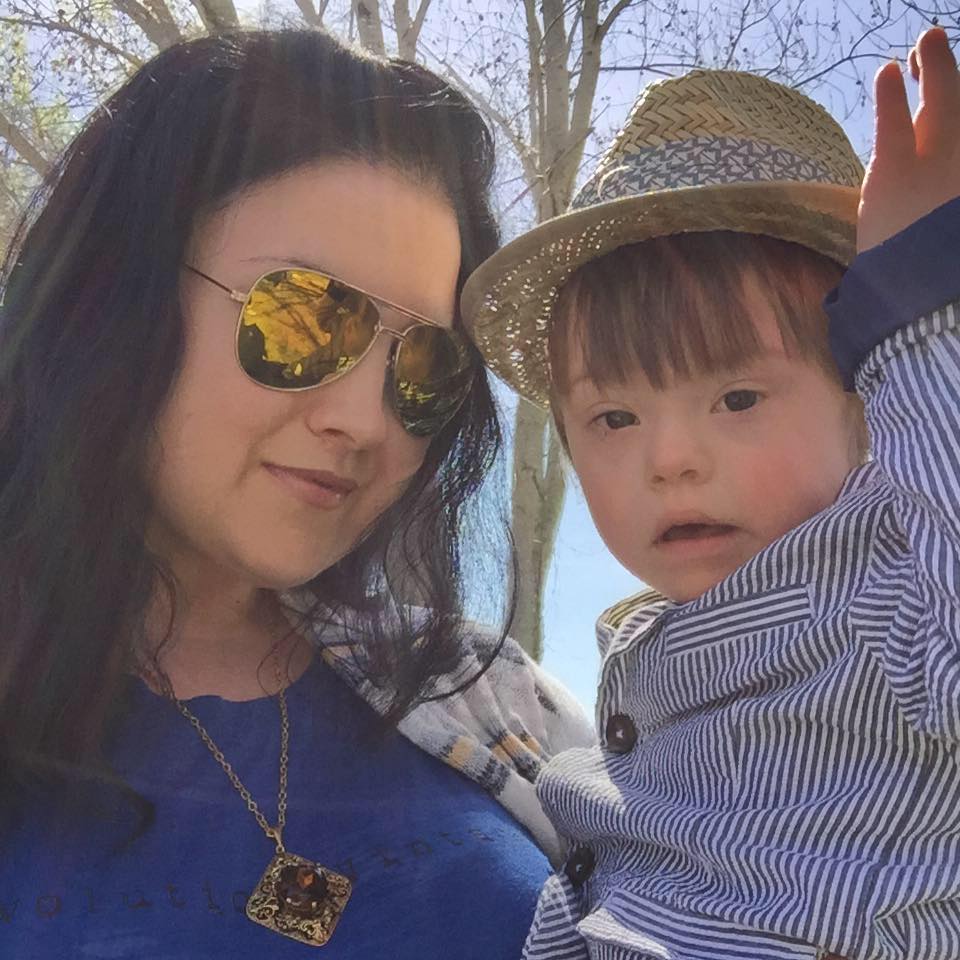 Mom wearing sunglasses, holding son wearing a hat