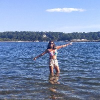 girl standing in lake with arms out