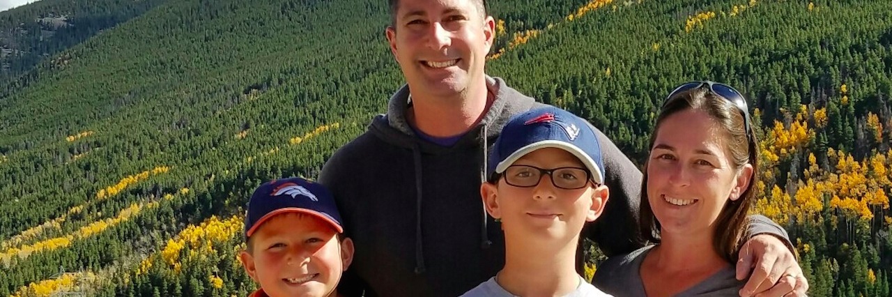 What People Don't See in My Son's Journey With Cyclic Vomiting Syndrome Denise and her family by the mountains