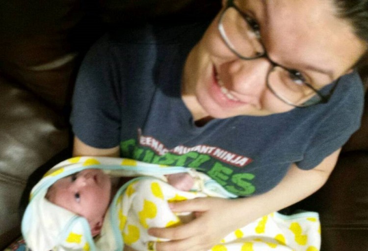 A woman holding her son, looking up at camera