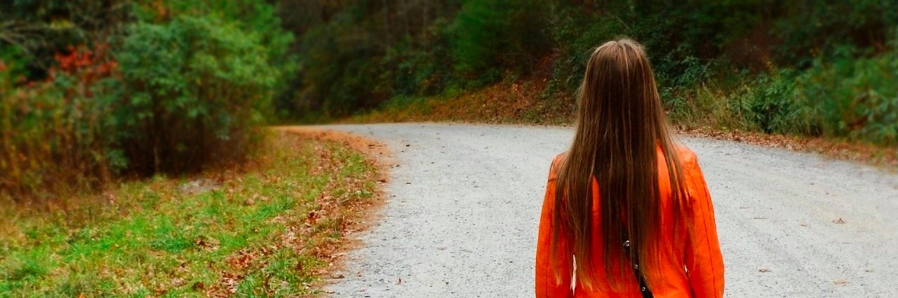 Making My Invisible Illness a Little More Visible Young woman walking down the road alone