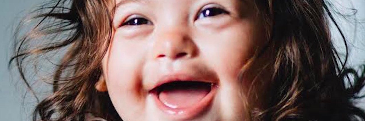 Helping Other Moms of Children With Down Syndrome girl smiling