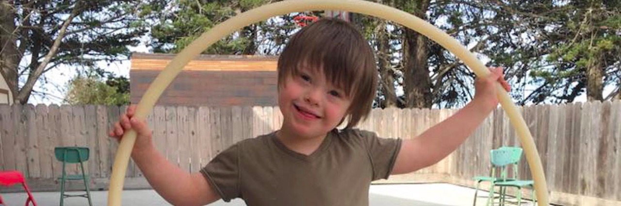 Ways to Advocate for People With Down Syndrome Boy standing in backyard with hula hoop
