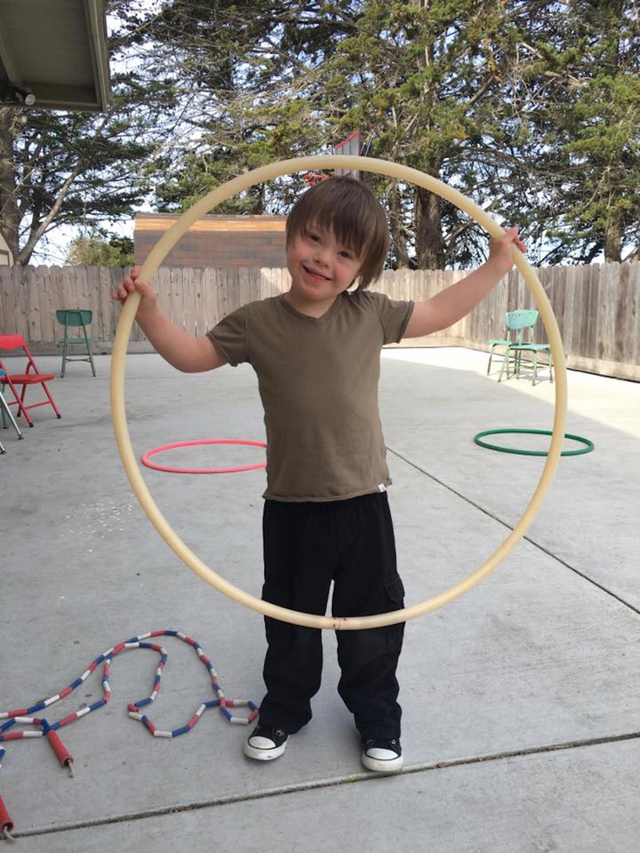 Boy standing in backyard with hula hoop
