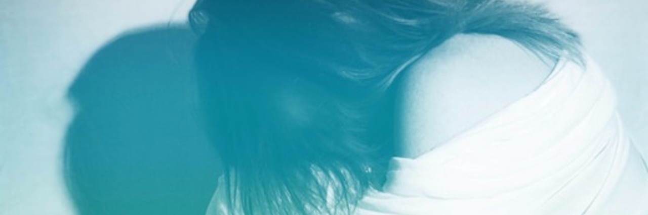 Embracing Positivity and Accepting My Life With Dysautonomia woman with white sheet wrapped around her and her face hidden