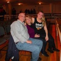 parents sitting with their daughter in an auditorium