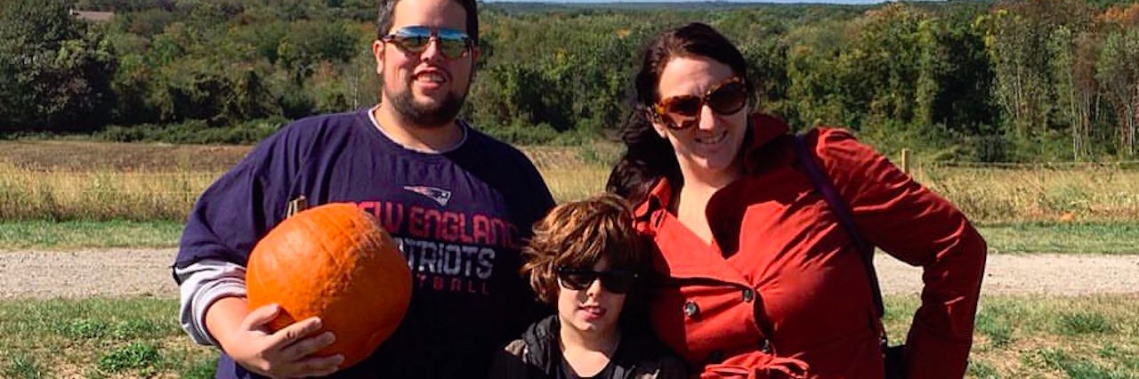 dad mom and son picking pumpkins