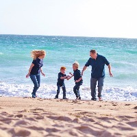 Mother and father with two sons on the shore at the beach