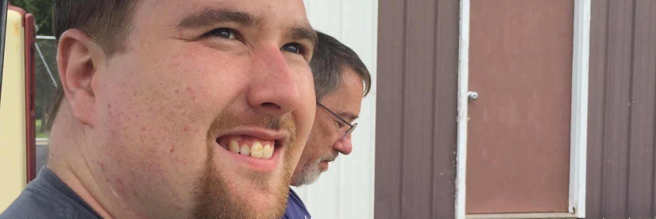 Autism: Being OK With Not Knowing the Future as My Son Became an Adult Photo of two men, one looking at his phone and the other looking to the side of the camera