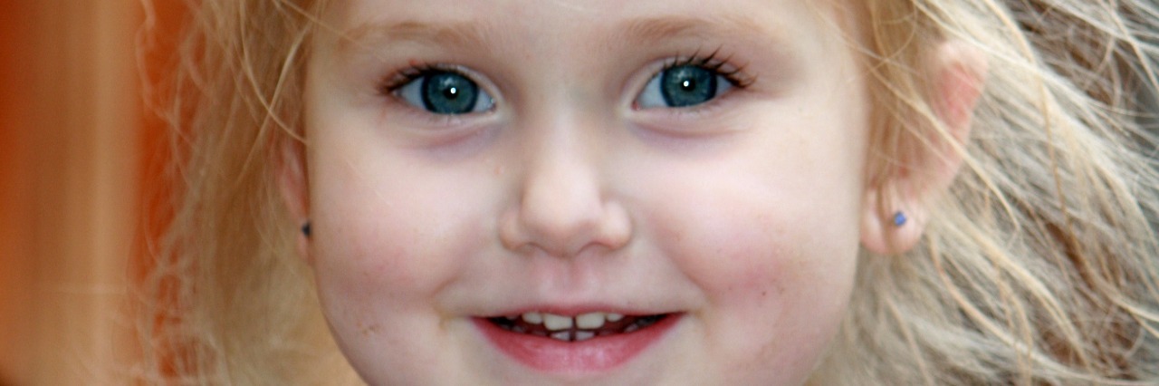 young girl in blue shirt smiling