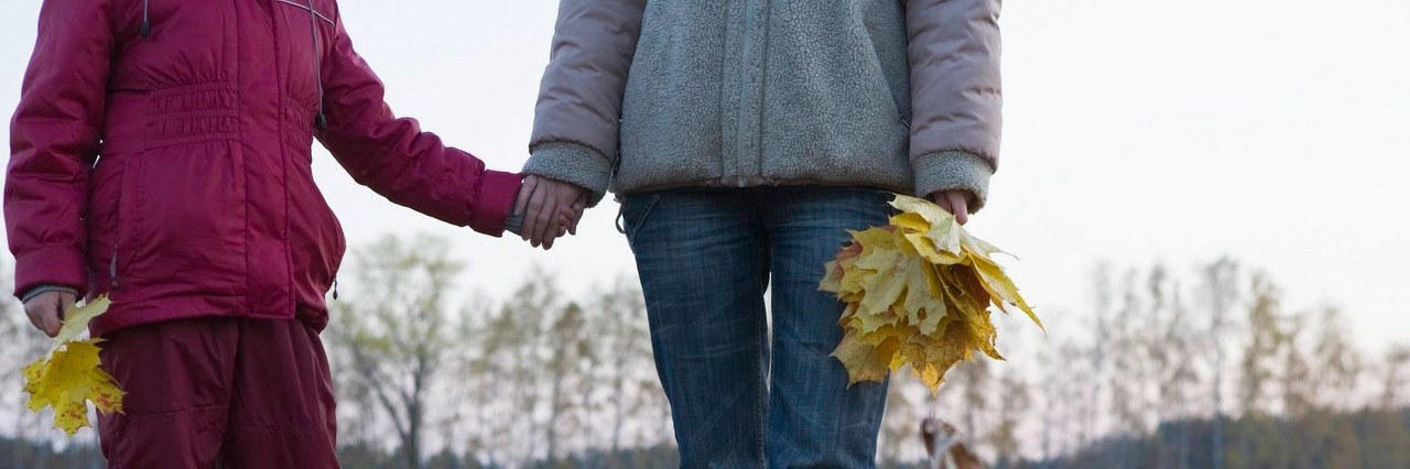 Letting Go of the Guilt I Feel as a Mom With Fibromyalgia Mother and daughter holding hands in field
