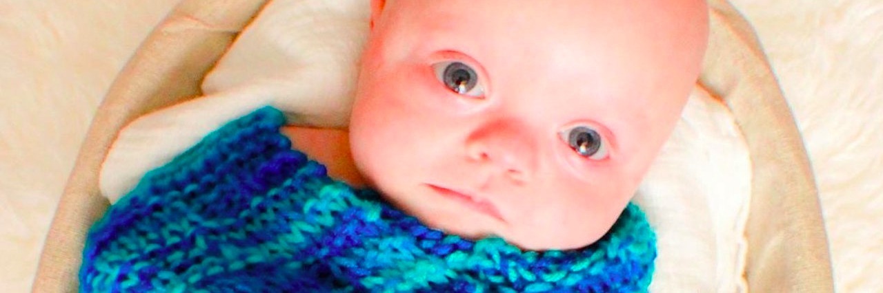 Lessons Our Baby With Down Syndrome Has Taught Us baby wrapped in a swaddle