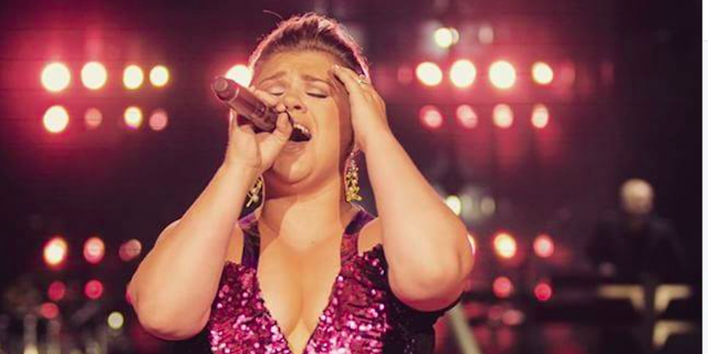 A female singer in a dress performing on stage