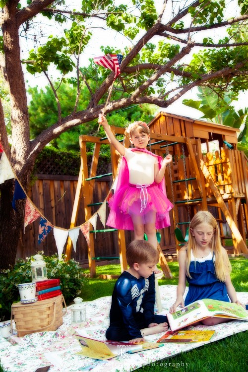 Young girl wearing a fairy costume outside with two other children