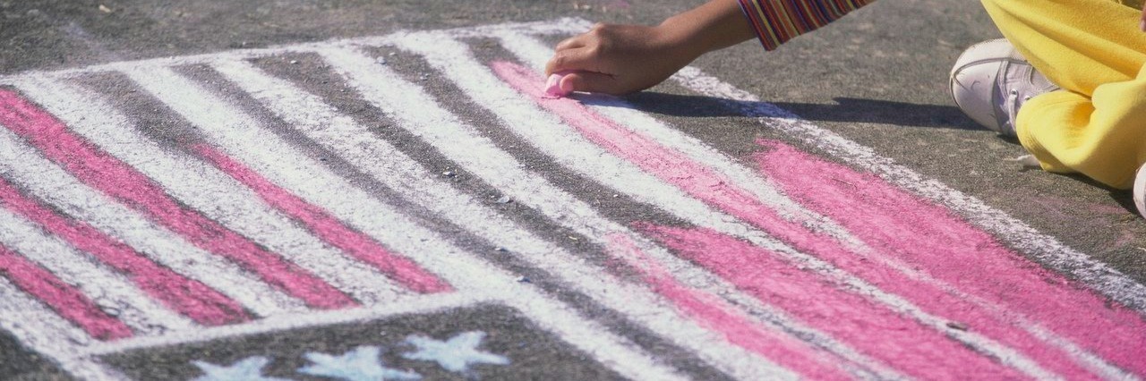 girl drawing the U.S. flag with chalk