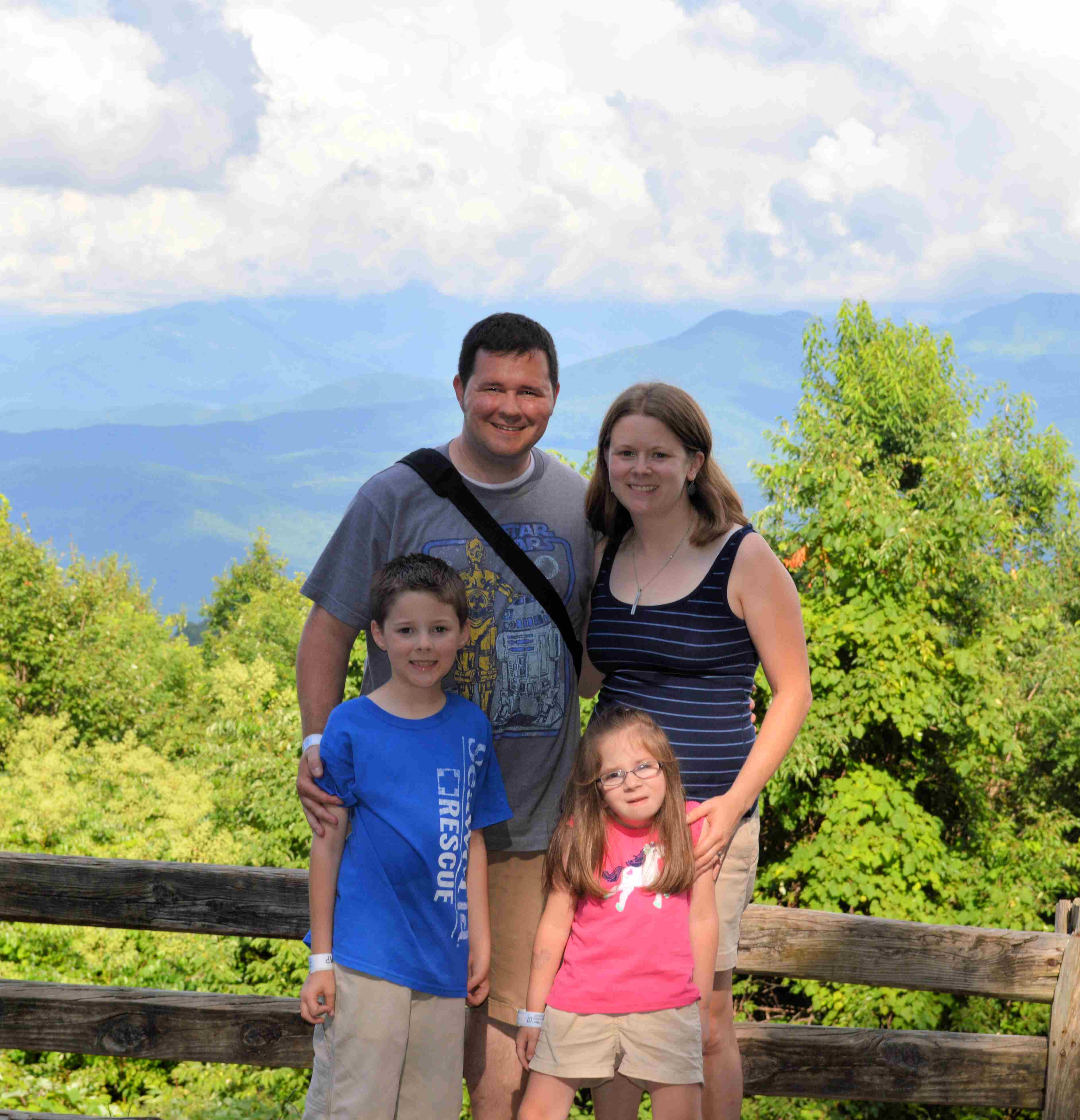 Julie and her family in front of a mountain landscape