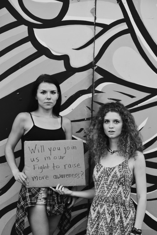 two women hold a sign that says will you join us in our fight to raise more awareness