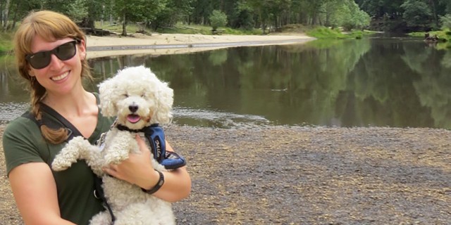Jen Pearlstein at Yosemite National Park with her cervice dog, a white poodle.