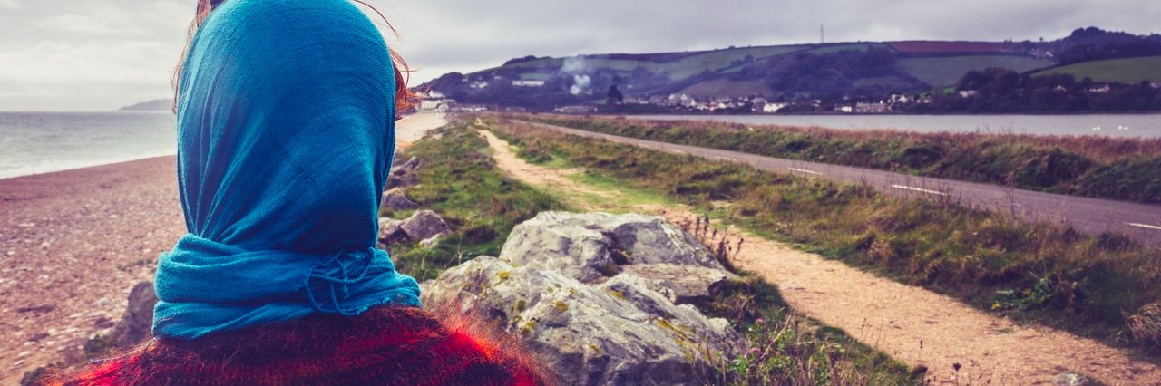 Chronic Illness: What I’ve Learned About Reconnecting With People woman admiring the sea on a cold autumn day