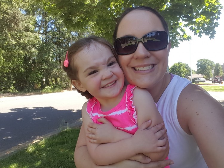 A woman with sunglasses holding her daughter