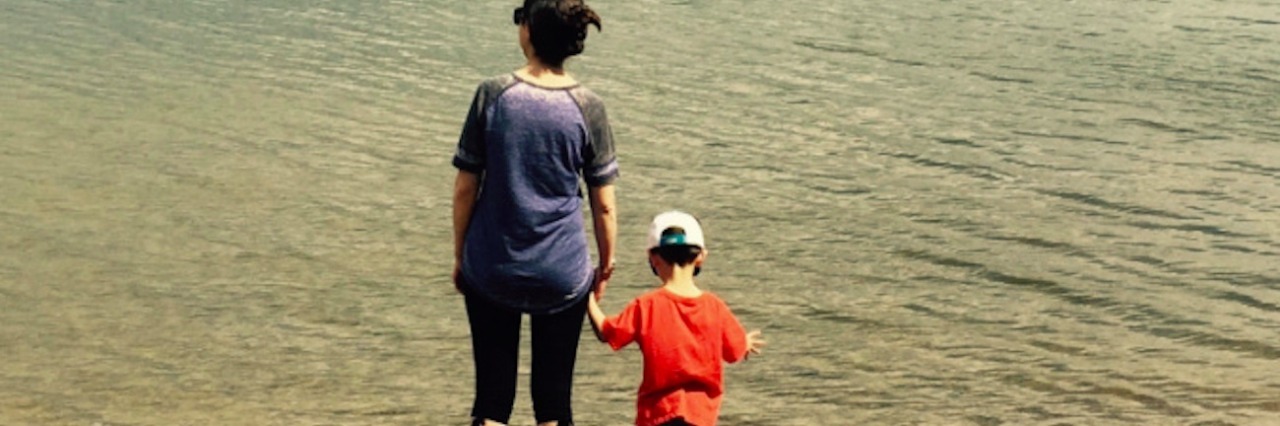 What It's Like Searching for a Diagnosis and Explaining My Symptoms A woman and child holding hands, standing at the shore