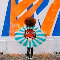 Girl standing in front of wall wearing cape with tiger on it