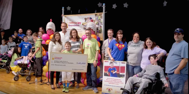 How We're Funding Miracles for Children With My Daughter's Rare Disease The Cal Foundation holding a check on stage