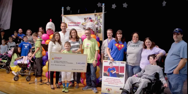 The Cal Foundation holding a check on stage