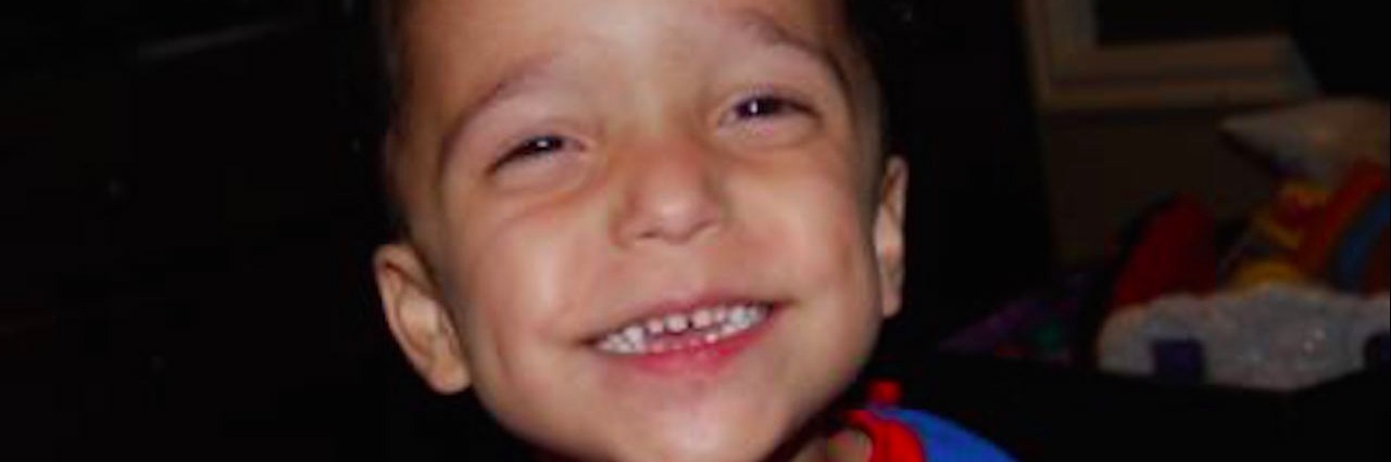 Parenting a Child With ADNP Syndrome: What to Know Sandra's son in his Superman shirt