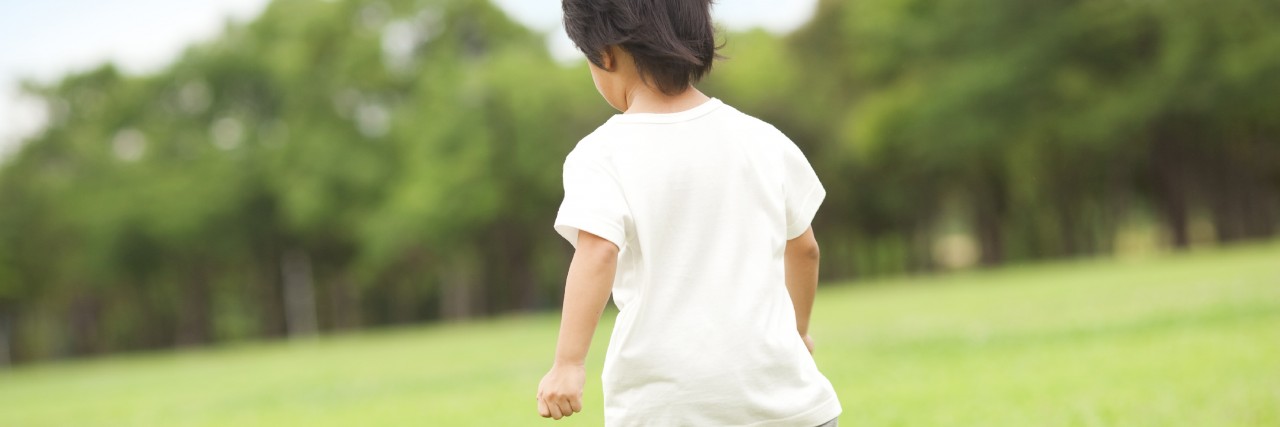 Boy running through field.