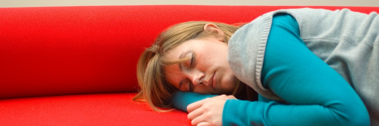 woman sleeping on red couch