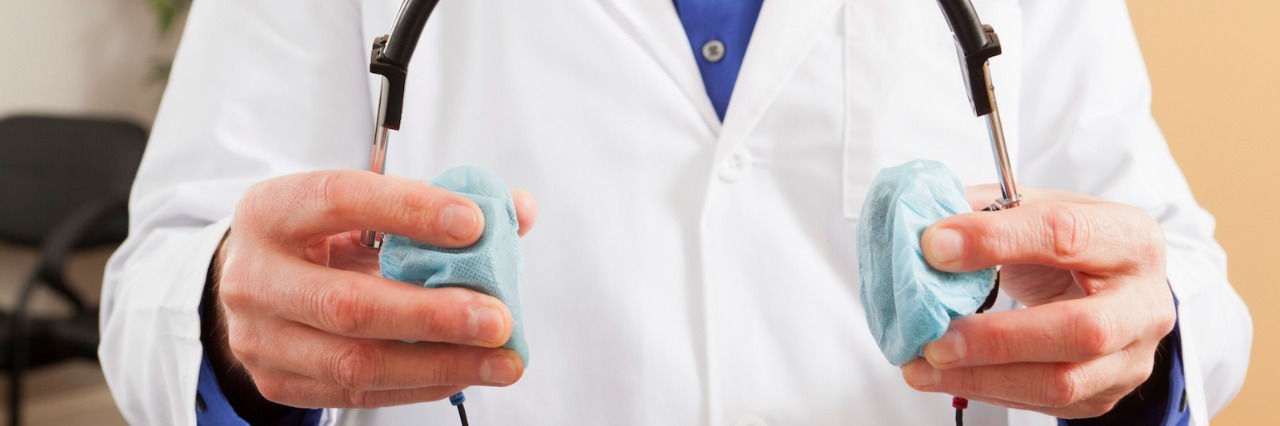 Why I Dread Getting My Hearing Tested But Do It Anyway Audiologist holding a headset for audiometric evaluation