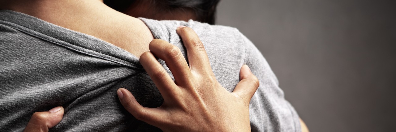 How Telling People With Mental Illness to 'Get Help' Can Be Misleading a woman hugging a friend, grabbing back