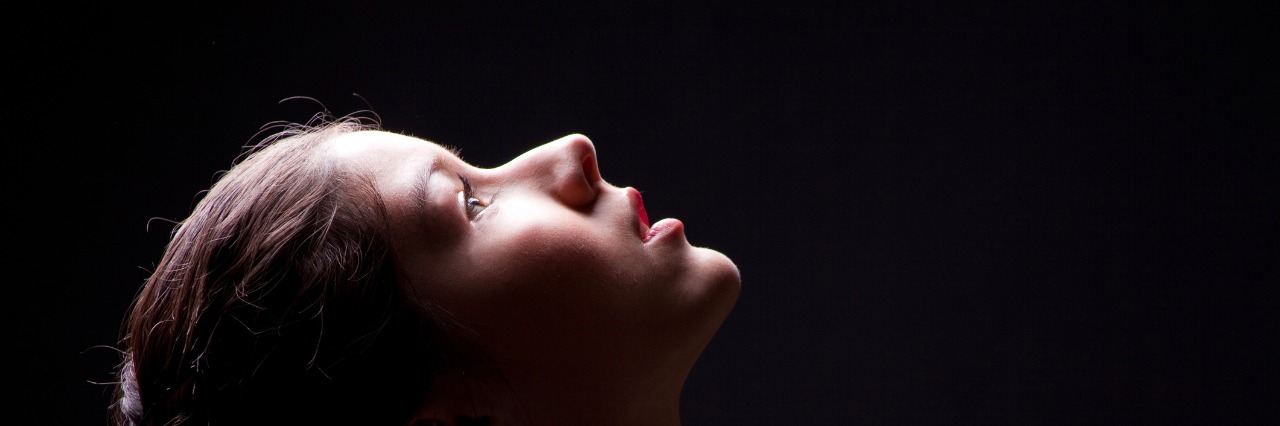 When There's No Easy Way to Describe Your Depression close up portrait of young girl looking up to light on black background
