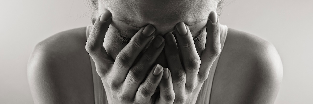 How Panic Attacks and Anxiety Attacks Are Different woman crying with her head in her hands