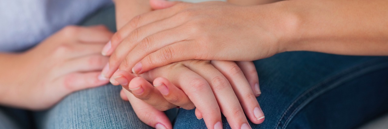 What No One Told Me After Someone I Love Was Diagnosed With Cancer Two people holding hands, comforting