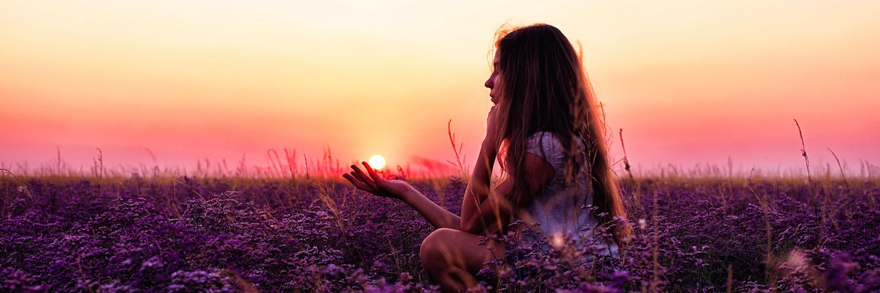 girl in a field of flowers at sunset