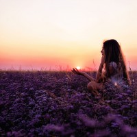 girl in a field of flowers at sunset
