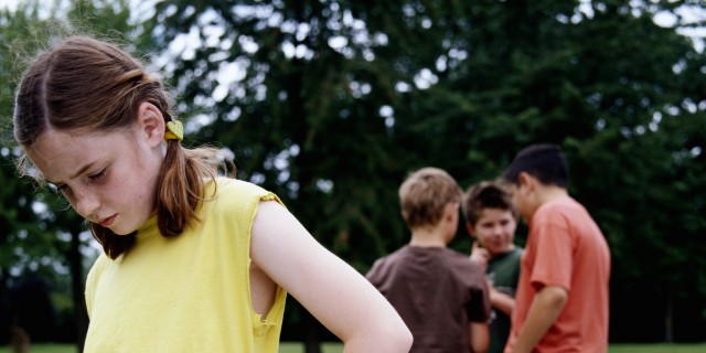 To the Boys Who Bullied Me in Middle School: I'm Finding My Worth Girl (9-11) in park hand on hip, looking down, boys in background