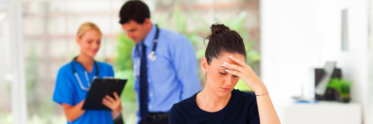 caucasian woman having headache and visiting doctor
