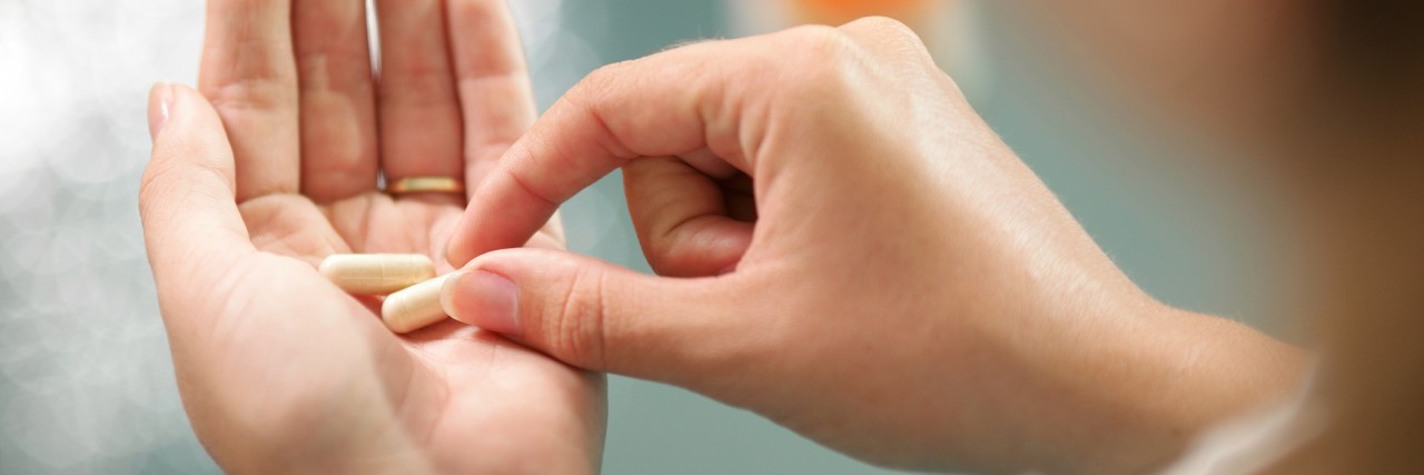 How I Came to Accept I Need Medication for Anxiety Close up view of young woman holding pills