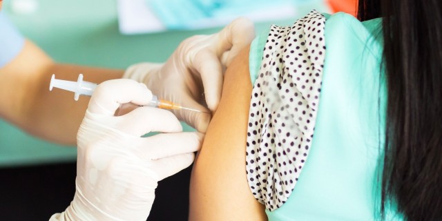 A Simple Guide to Getting a Flu Shot This Year doctor giving woman an injection in her upper arm