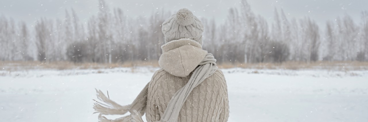 Why the Cold Weather Can Be a Trigger for Cyclic Vomiting Syndrome Woman on a meadow in winter