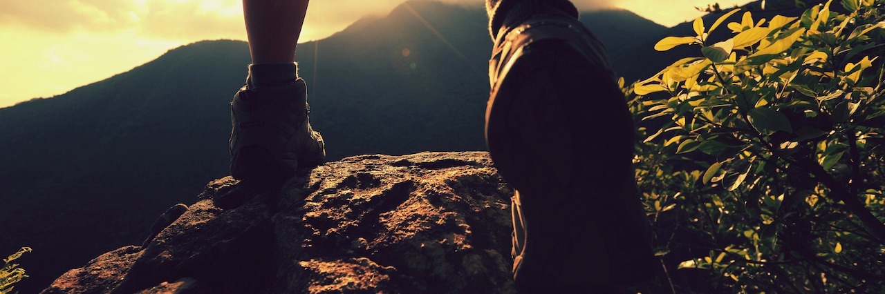 What I Have Learned From Having Mental Illnesses woman hiking up a mountain towards the sunset