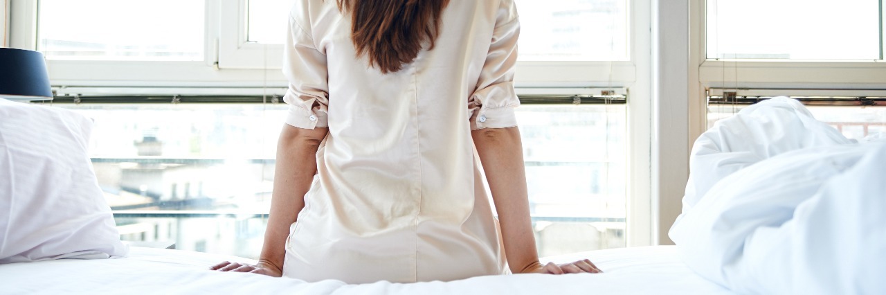 Raising Awareness About Dysautonomia and POTS woman sitting on the edge of her bed