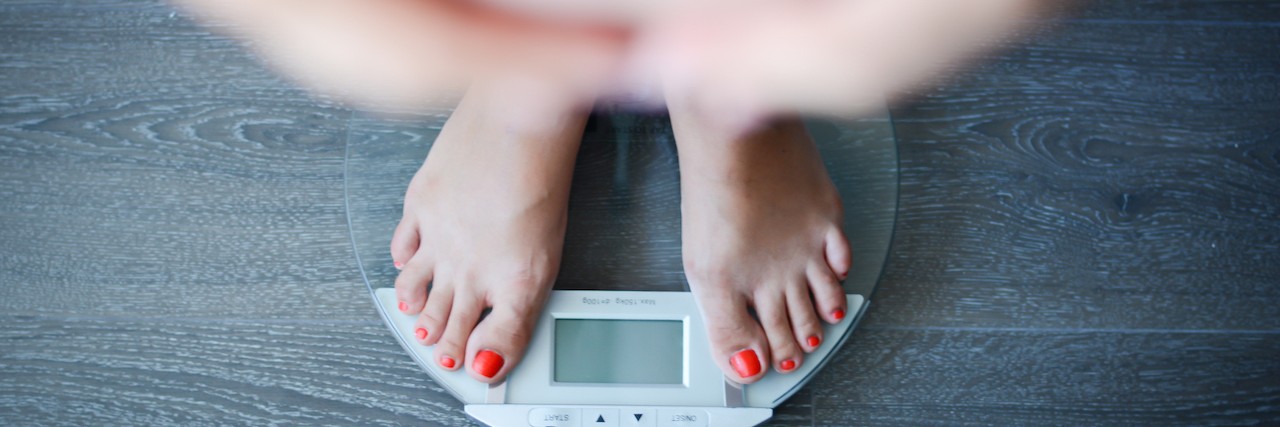 Viewing Weight Gain Positively After Overcoming Anxiety woman standing on a scale