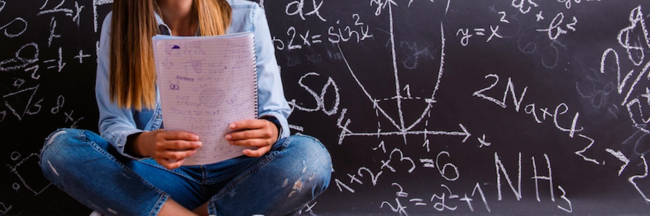 Tips for Surviving School With a Mental Illness young student in front of a chalkboard